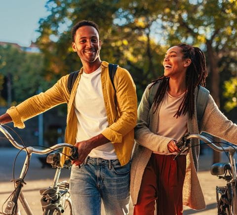 man and woman pushing bikes