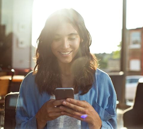 woman looking in the phone and smiling