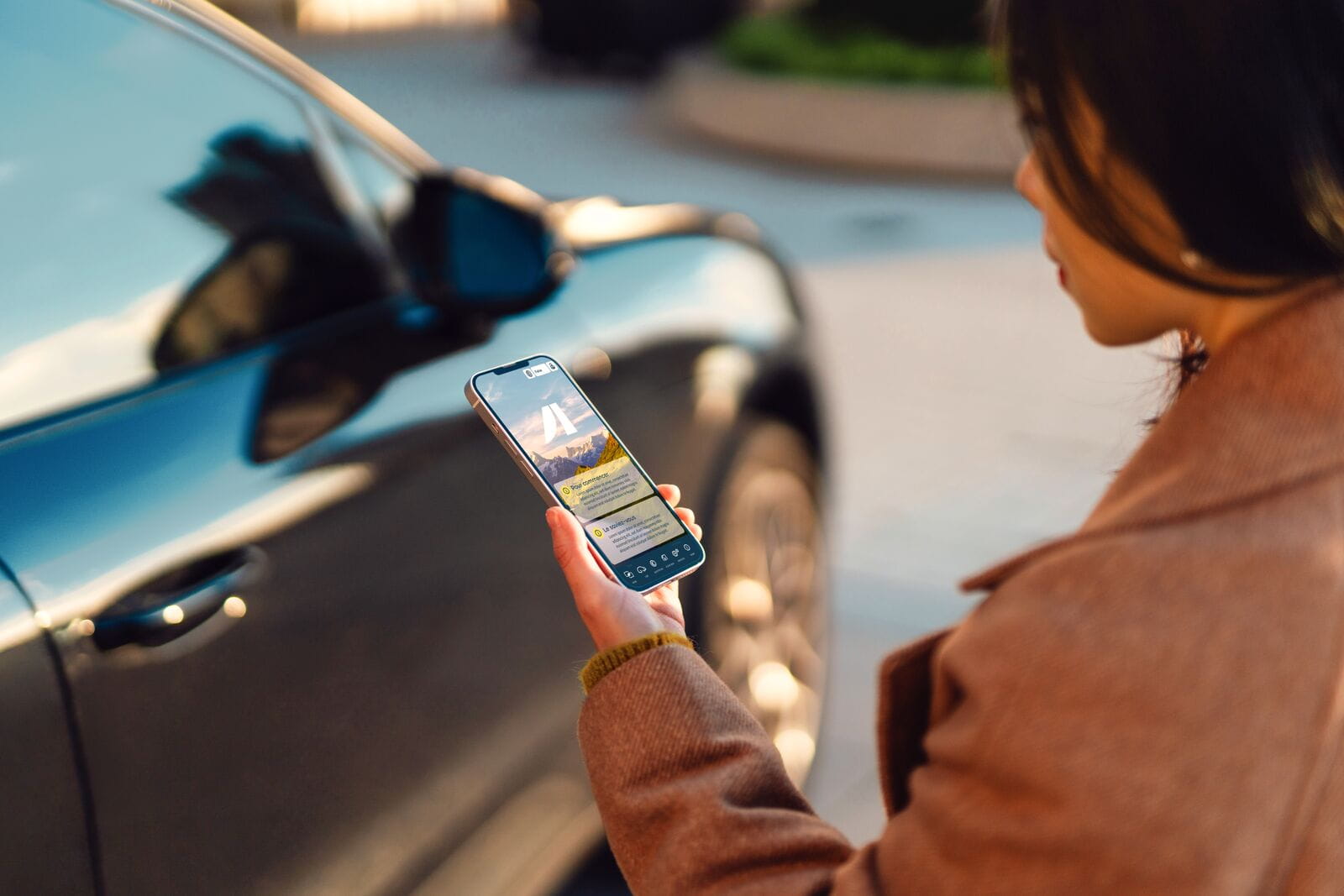 Femme tenant son smartphone pour réserver une voiture en autopartage
