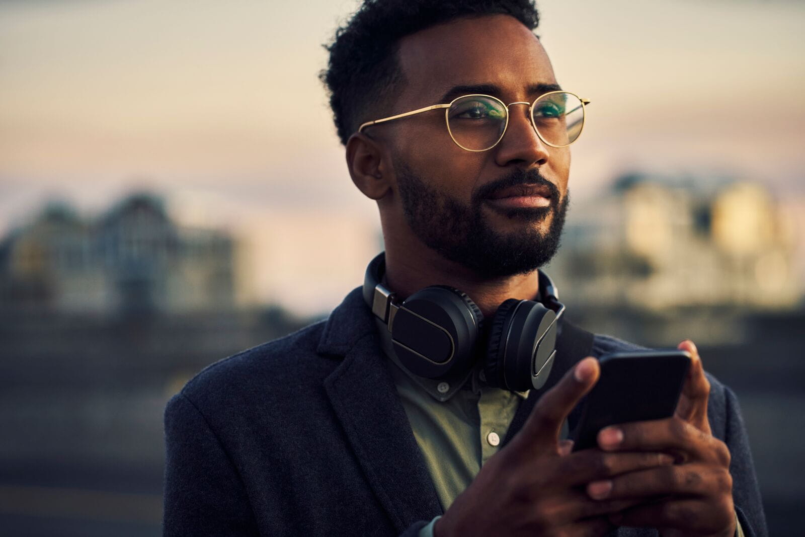 image d'un homme avec un casque audio tenant un smartphone