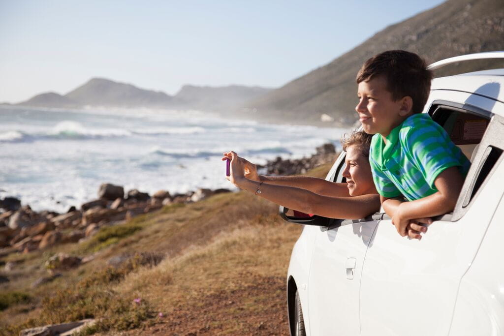 Mãe e filho a tirar foto à praia dentro do carro