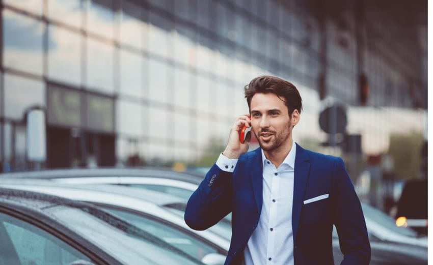 banner-guy-standing-beside-cars-talking-in-phone