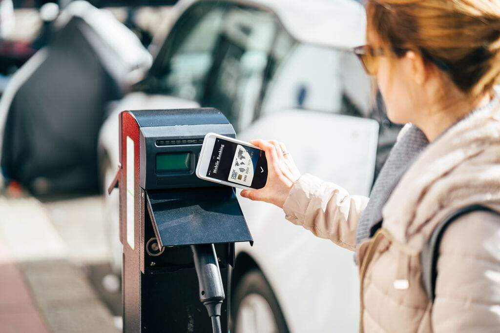 ustomer paying with digital wallet at electric vehicle charging station